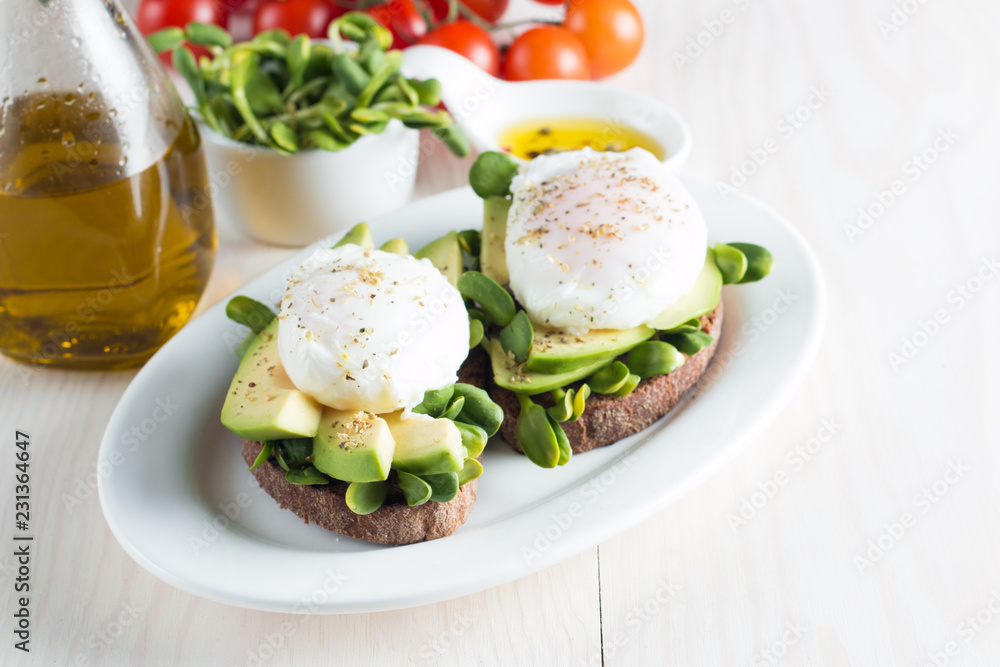 Avocado toast, cherry tomato on wooden background. Breakfast with toast avocado, vegetarian food, healthy diet concept. Healthy sandwich with avocado and poached eggs. Avocado toast, cherry tomato on wooden background. Breakfast with toast avocado, vegetarian food, healthy diet concept. Healthy sandwich with avocado and poached eggs.
