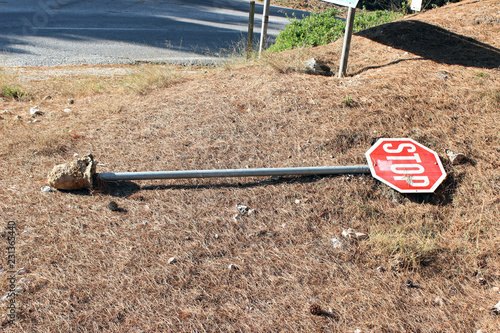 Broken stop traffic sign on the ground concrete base horizontal