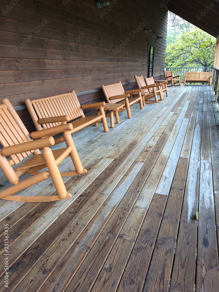 long row of wooden chairs on porch
