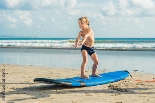 Photography Little boy surfing on tropical beach