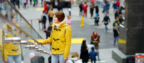 Happy young woman tourist sightseeing at Times Square in New York City. Female traveler enjoying view of downtown Manhattan.