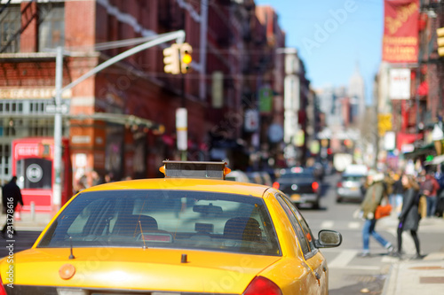 Yellow taxi cabs and people rushing on busy streets of downtown Manhattan.