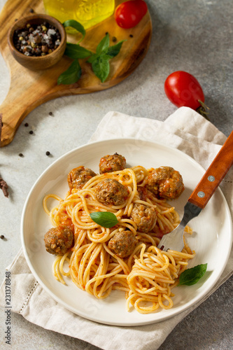 Italian style pasta dinner. Spaghetti with Meatballs with Tomato Sauce on stone or concrete table.