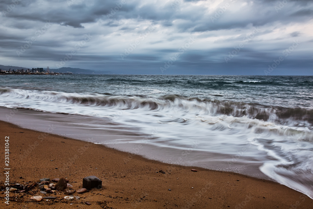 Overcast evening in Barcelona beach, waves and stormy clouds