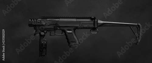modern black submachine gun on a black