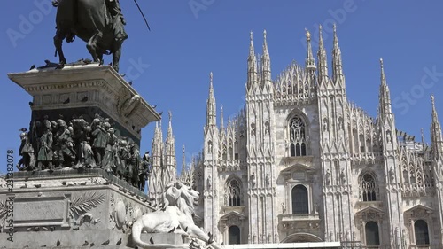 The Milan Cathedral (Duomo di Milano) and monument to Victor Emanuel II in the Piazza del Duomo in Milan, Italy, slider dolly shot 4k photo