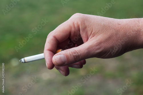 closeup of man with cigarette in hand in outdoor