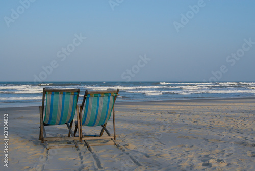 Two beach chairs on the beach.