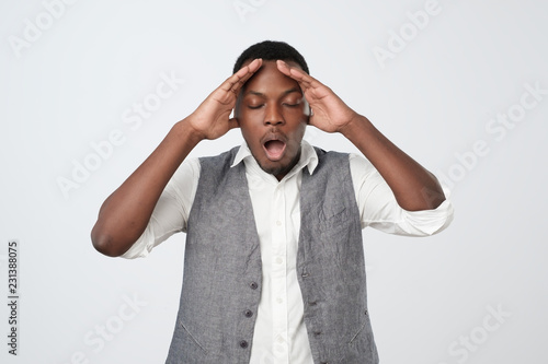 African young man, slapping hand on head having a duh moment isolated on gray background. photo