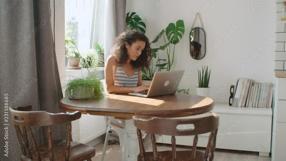 Charming young woman typing on laptop computer at home. Charming young woman typing on laptop computer at home.