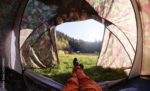 Obraz na plátne first person view from the tent in campsite on a tents on a green grass in a pine woods in fall at morning