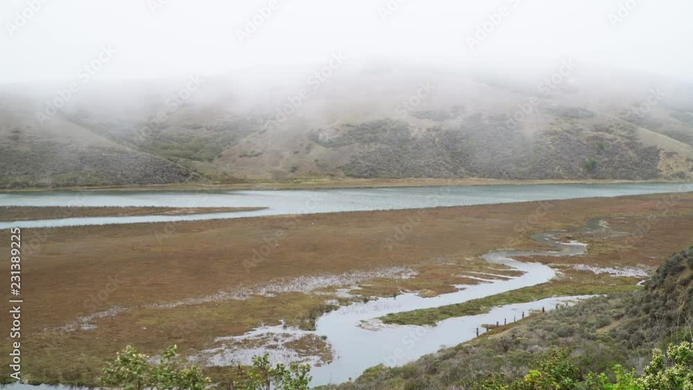 Keys Creek on the north east side of Tomales Bay, north of San Francisco along the Pacific Coast Highway. High tide flooding the salt marsh creek. Low clouds and fog. Keys Creek on the north east side of Tomales Bay, north of San Francisco along the Pacific Coast Highway. High tide flooding the salt marsh creek. Low clouds and fog.