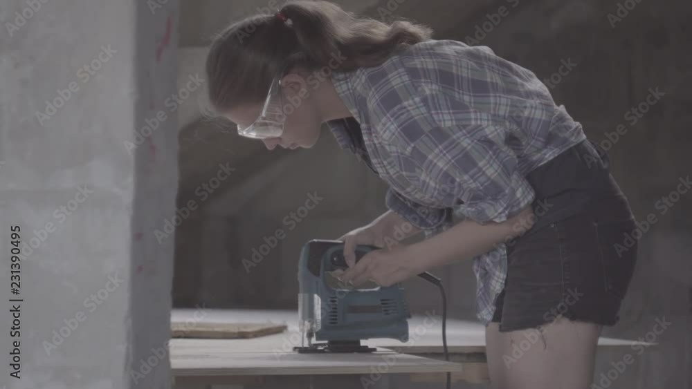 Girl carpenter working with jigsaw Girl carpenter working with jigsaw