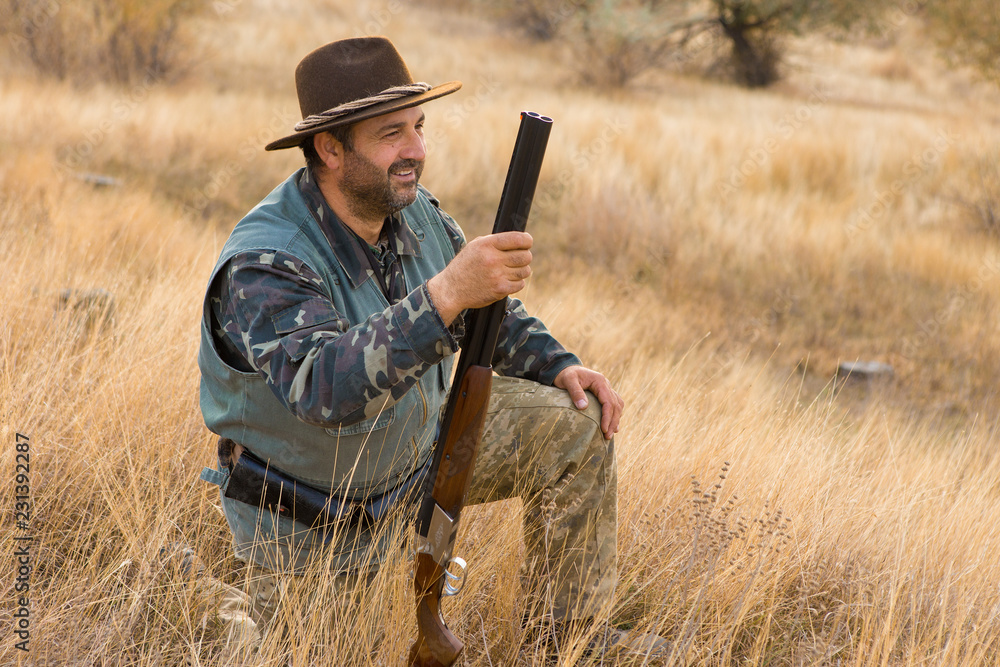 Hunter with a hat and a gun in search of prey in the steppe Hunter with a hat and a gun in search of prey in the steppe