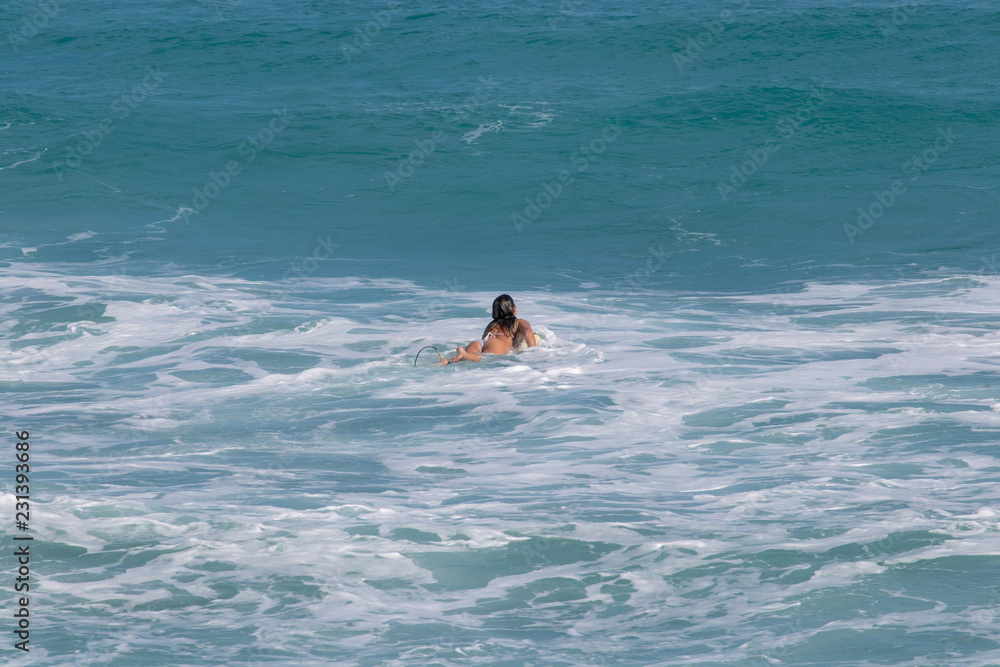 young girl waiting for a wave to surf