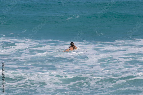 young girl waiting for a wave to surf