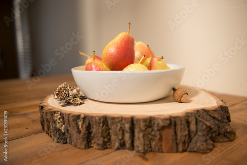 Bowl of organic pears on wood in autumn