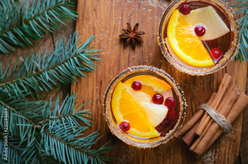 Winter Cocktail, Christmas Sangria with Apple Slices, Orange, Cranberry and Spices, Refreshing Drink on Wooden Background