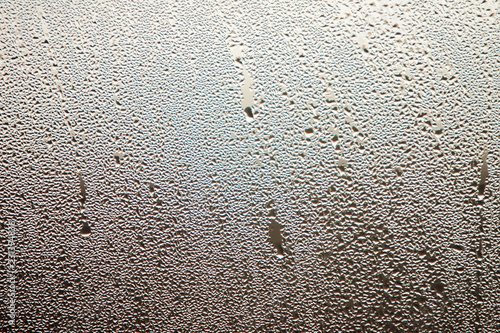 Raindrops on the fogged glass with gray background