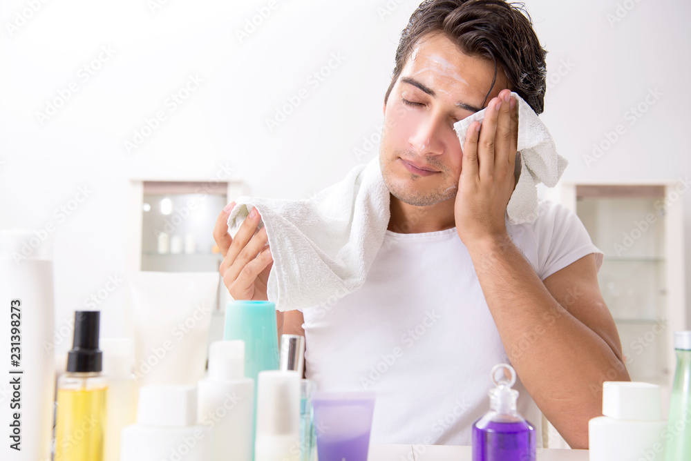 Young handsome man in the bathroom in hygiene concept Young handsome man in the bathroom in hygiene concept