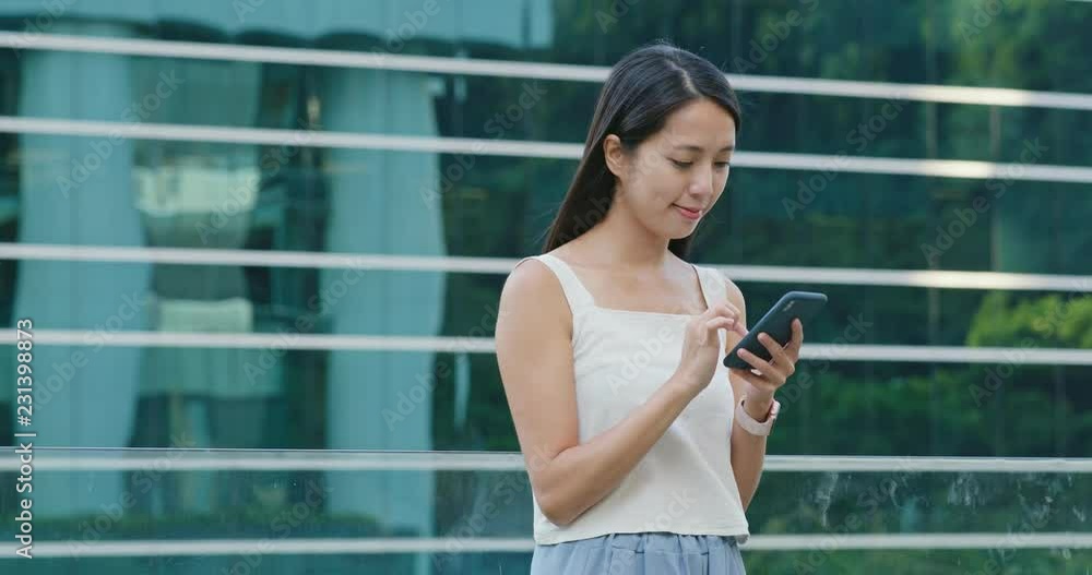 Woman talk to mobile phone over the business tower background Woman talk to mobile phone over the business tower background