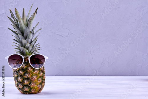 Pineapple wearing sunglasses and copy space. Fresh organic ananas in sunglasses and text space. Summer vacation concept.