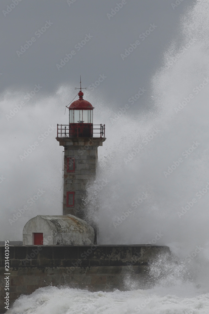 Waves splash over lighthouse