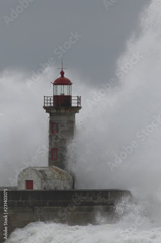 Waves splash over lighthouse