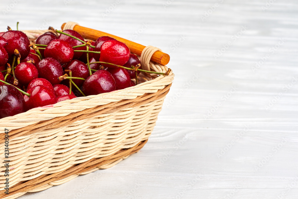 Sweet cherries in basket and copy space. Ripe red cherries with water drops in basket. Fresh from garden. Tasty seasonal berry. Sweet cherries in basket and copy space. Ripe red cherries with water drops in basket. Fresh from garden. Tasty seasonal berry.