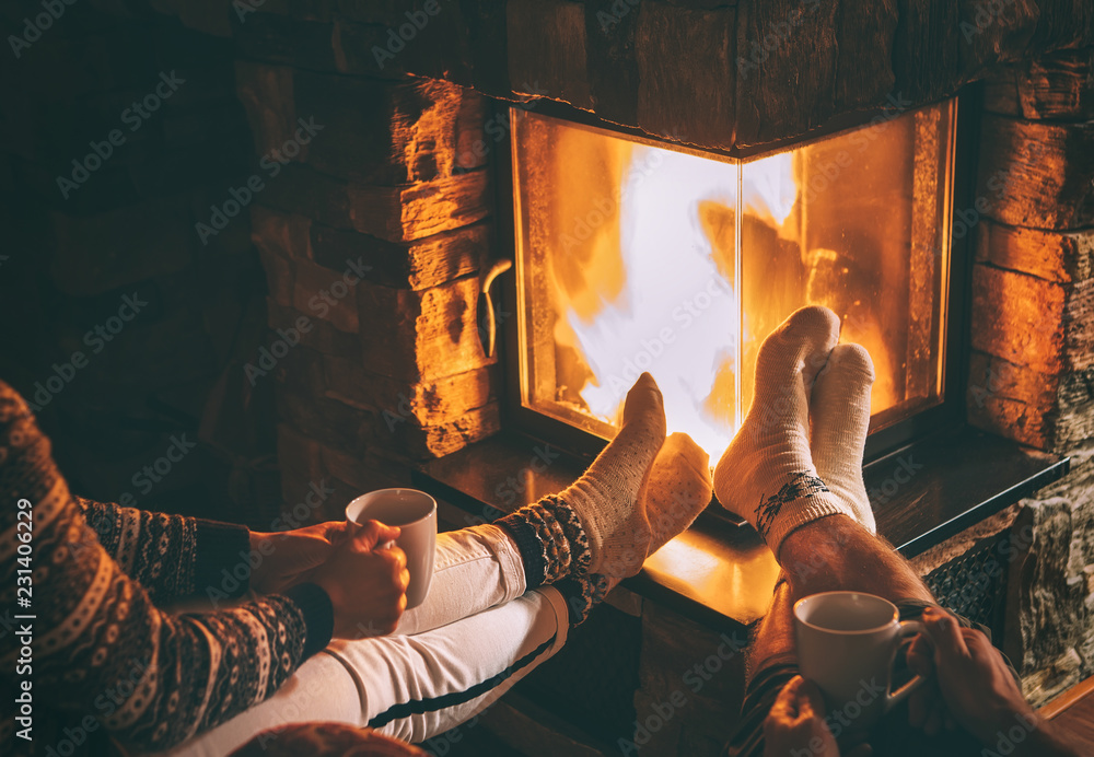 Couple in love sitting near fireplace. Legs in warm socks close up image.  Cozy Christmas Home atmosphere Stock Photo | Adobe Stock