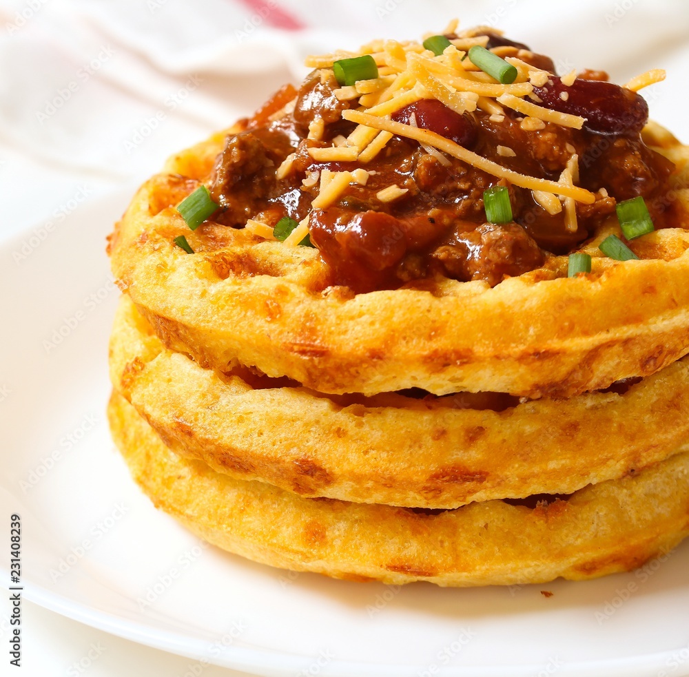 Close up of Cornbread cheddar waffles with bean chili isolated on white Close up of Cornbread cheddar waffles with bean chili isolated on white