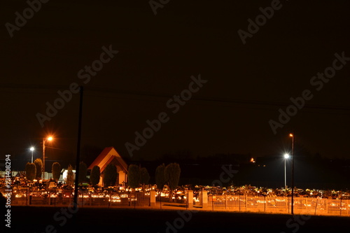 Cmentarz w nocy oświetlony zniczami
