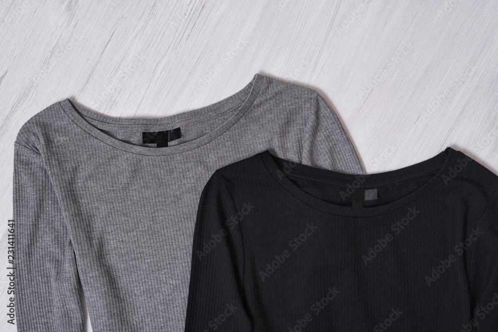 Black and gray tops on wooden background. Close up. Fashionable concept Black and gray tops on wooden background. Close up. Fashionable concept
