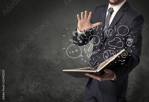 Businessman holding book with doodle drawings and signs.