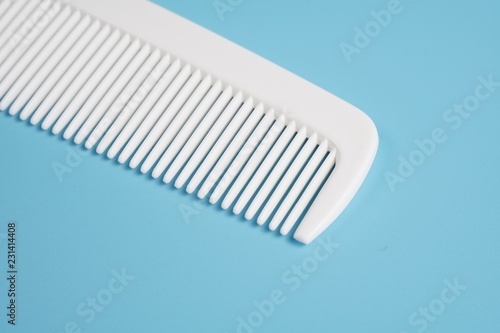 White hair comb isolated on blue background