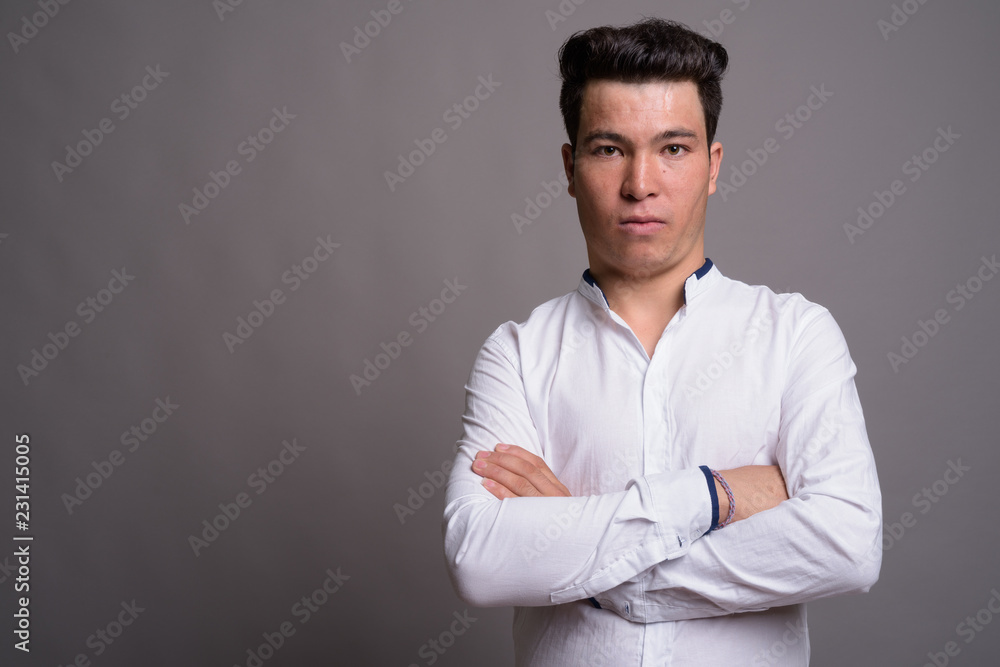 Portrait of young Asian businessman against gray background Portrait of young Asian businessman against gray background