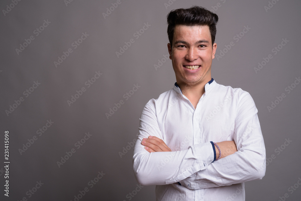 Portrait of young Asian businessman against gray background Portrait of young Asian businessman against gray background