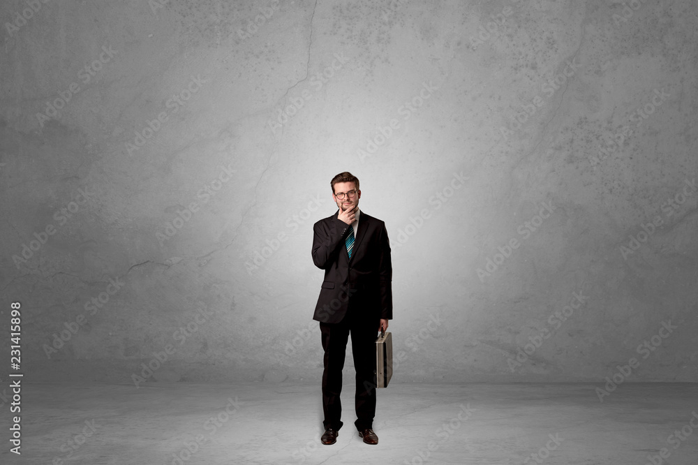 Alone handsome businessman standing in a dark empty room Alone handsome businessman standing in a dark empty room