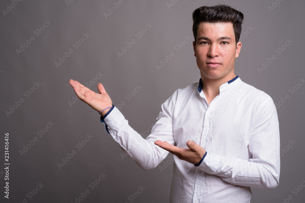 Portrait of young Asian businessman against gray background Portrait of young Asian businessman against gray background
