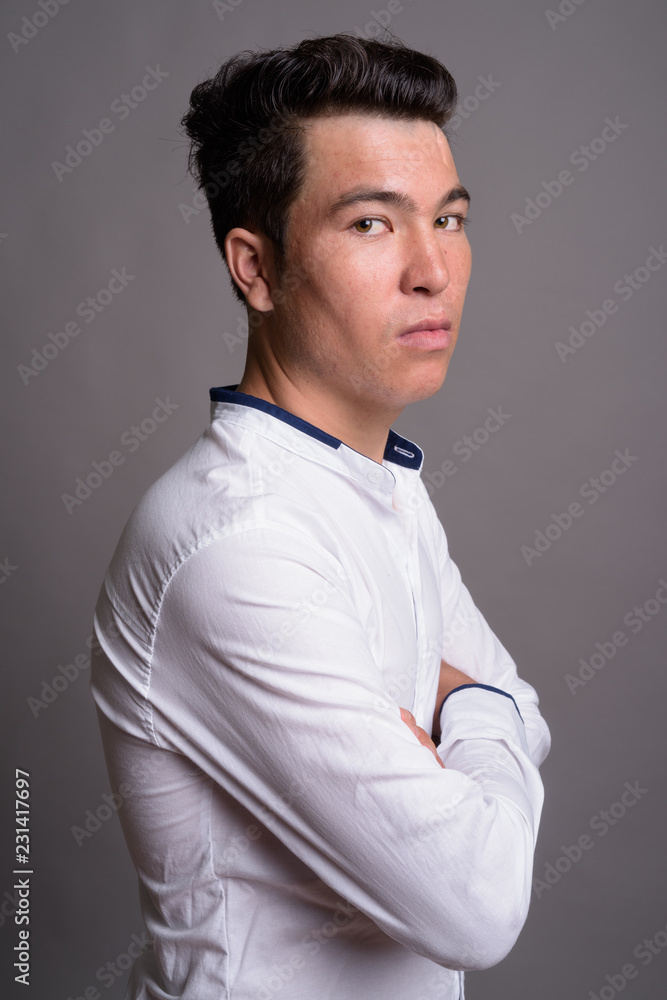 Portrait of young Asian businessman against gray background Portrait of young Asian businessman against gray background