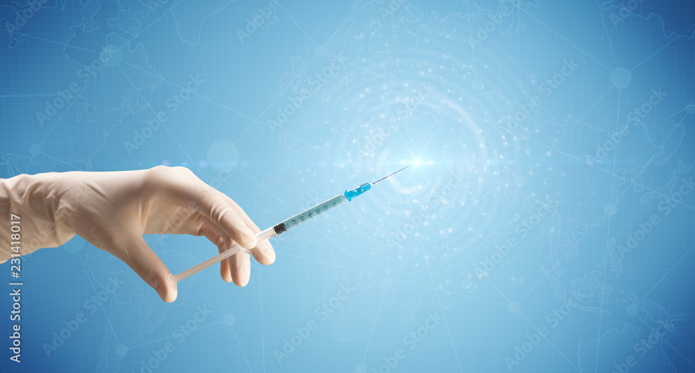 Naklejka premium Female doctor hand holding syringe with blue background and shine