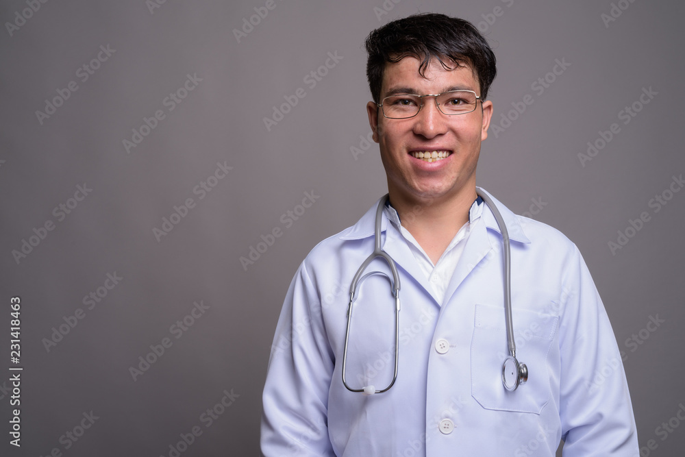 Young Asian man doctor against gray background Young Asian man doctor against gray background