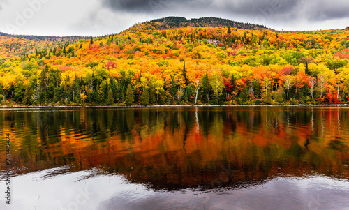 Fall colors of Lac Legault with Mont Kaaikop in the background, in cottage country in the Laurentians, Quebec, Canada.