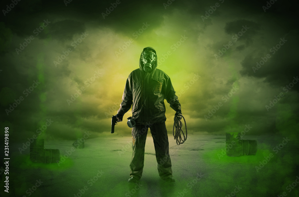 Fototapeta premium Masked unrecognizable guard in an abandoned space after explosion 