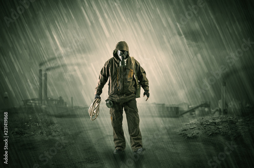 Gas masked survival man coming with arms on his hand  in a demolished dark environment    © ra2 studio