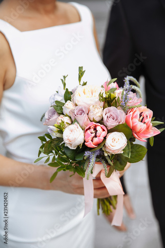 A bride holds  wedding bouquet consisting of different flowers. Decoration Artwork. Soft. selective focus