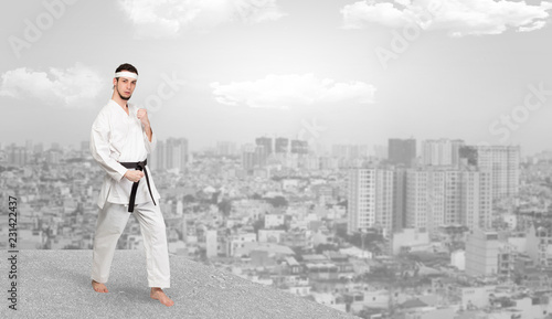 Young karate trainer doing karate tricks on the top of a metropolitan city 