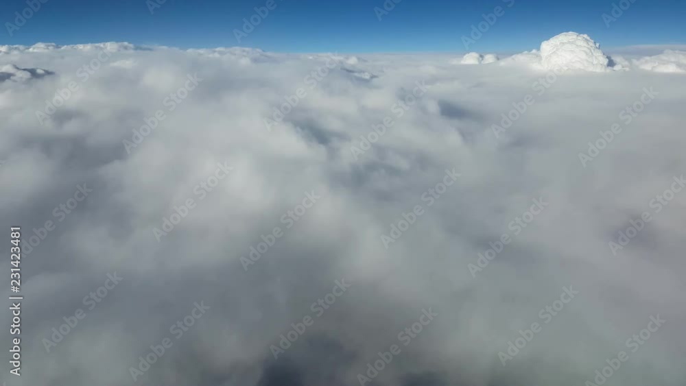 Arty view of rough and ragged white clouds from an airplane window on sunny day in summer.The shimmering celeste sky is above. Arty view of rough and ragged white clouds from an airplane window on sunny day in summer.The shimmering celeste sky is above.