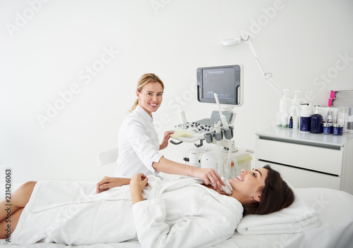 Portrait of beautiful woman in white bathrobe lying on daybed during medical examination at wellness center