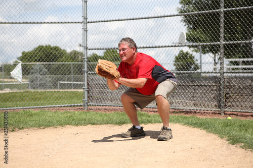 Father coach being catcher at a baseball practice © soupstock